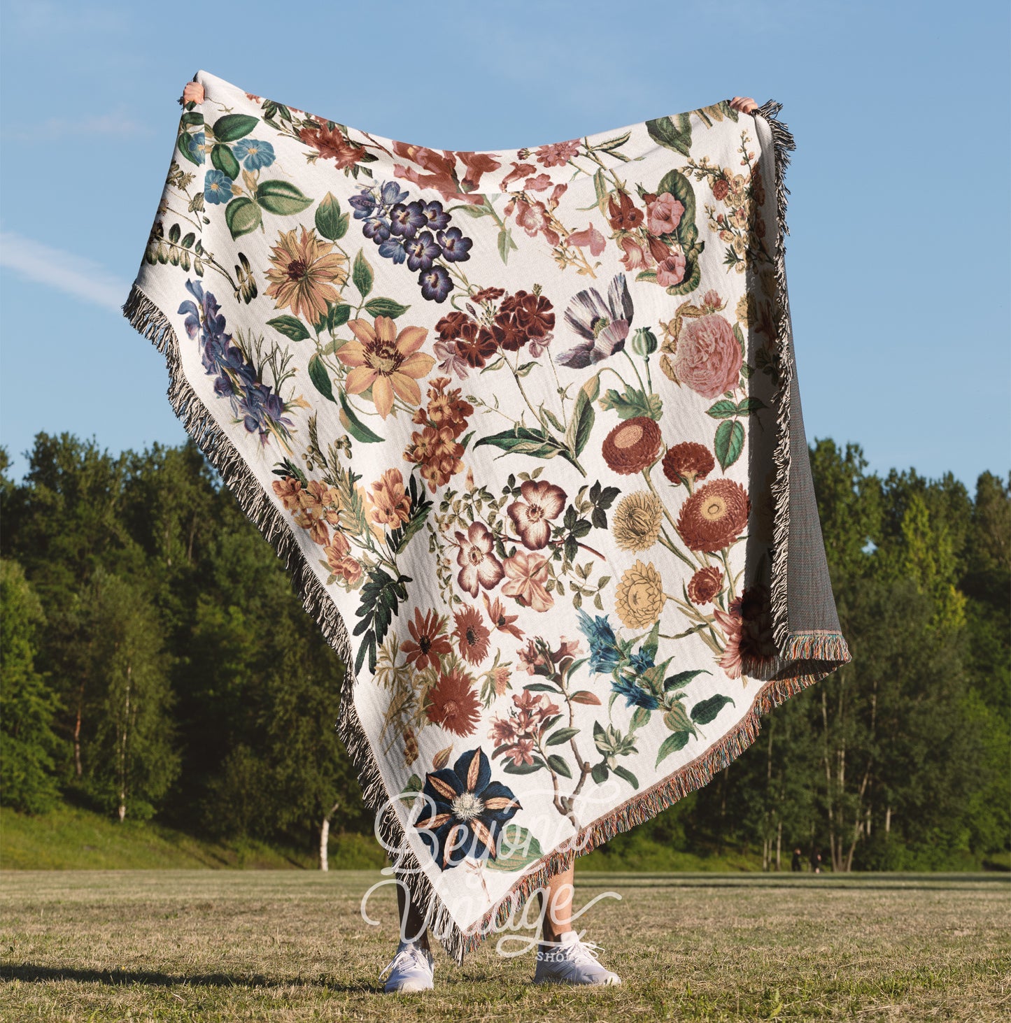 a woman is holding a blanket in a field