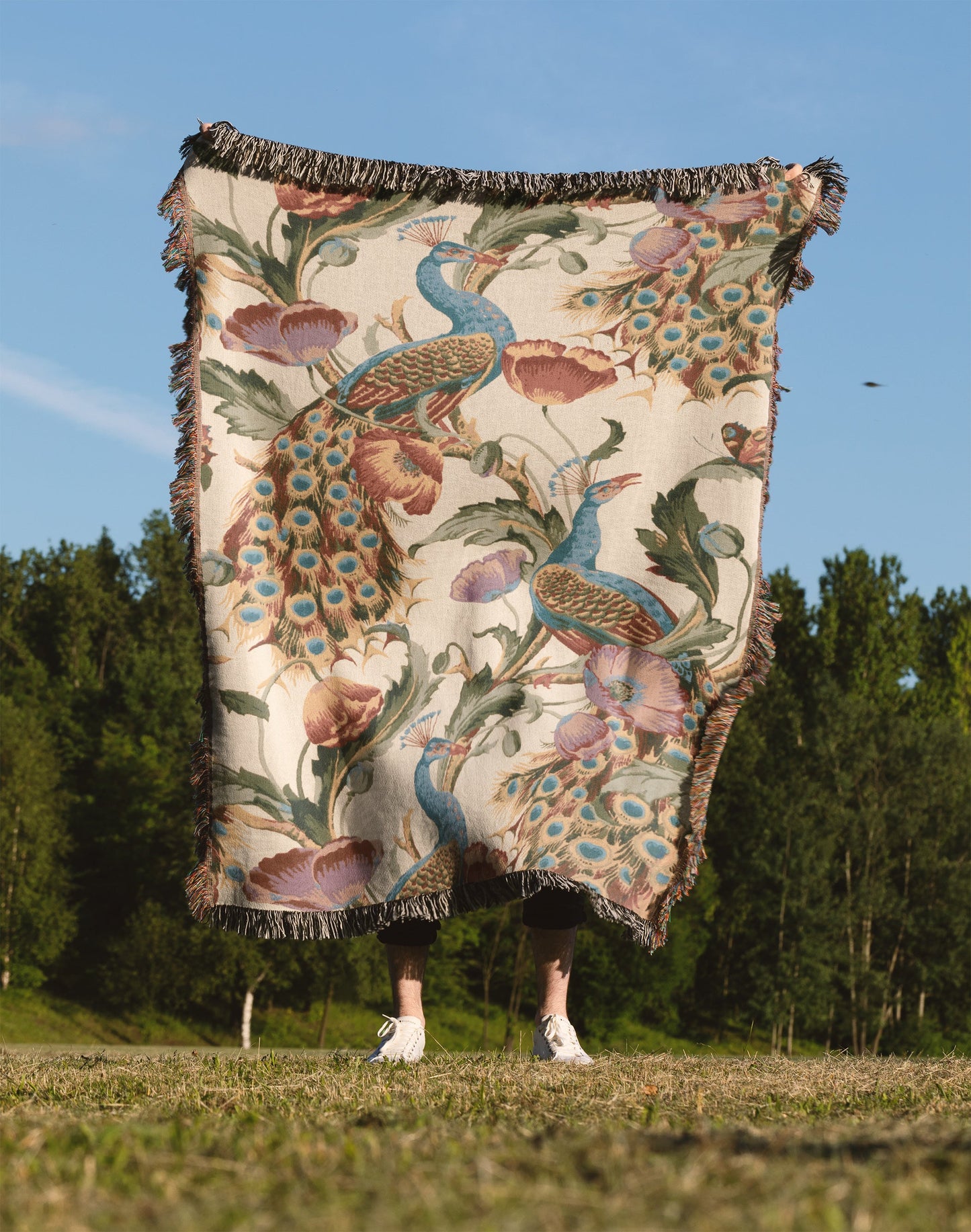 a person standing in a field holding a blanket