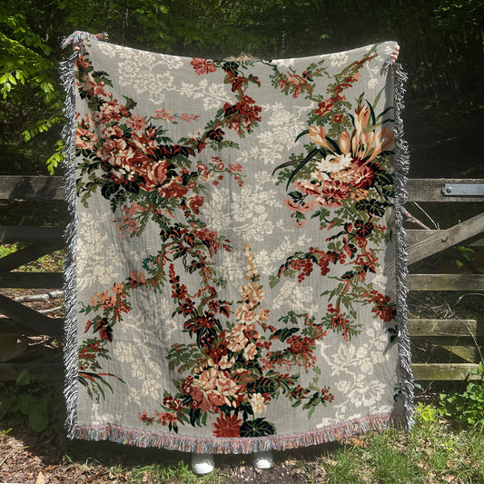 a quilt hanging on a wooden fence in the grass