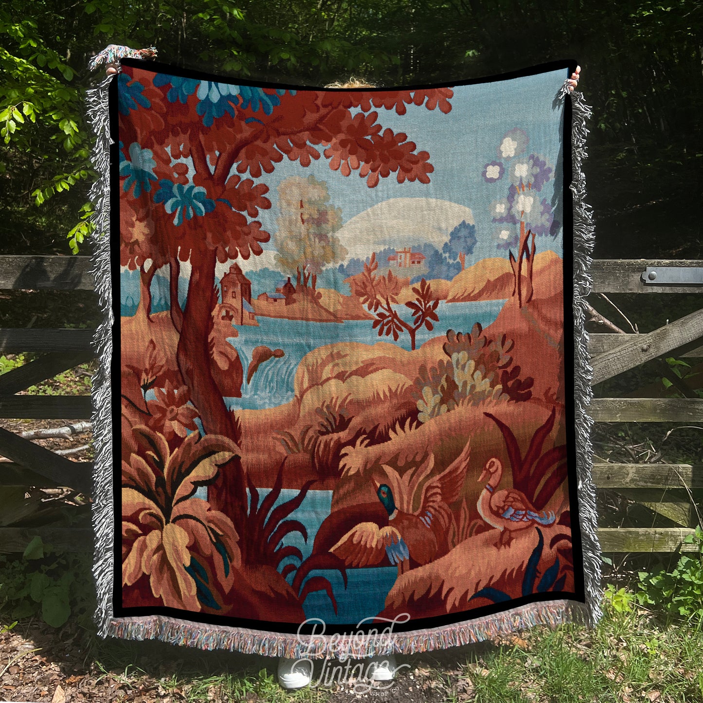 a tapestry hanging on a fence in the woods