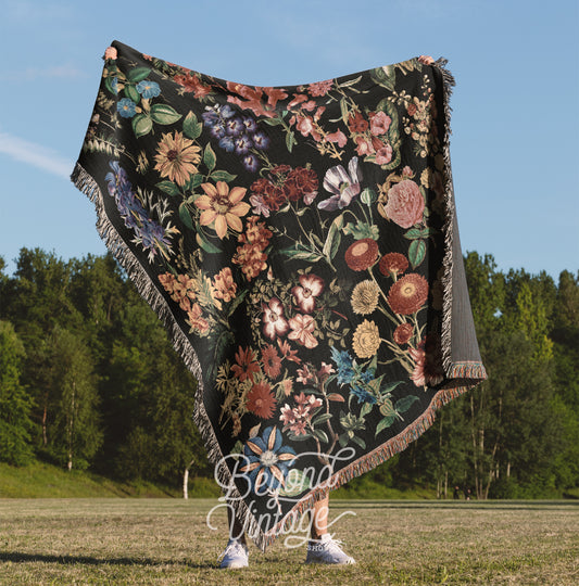 a woman standing in a field holding a blanket