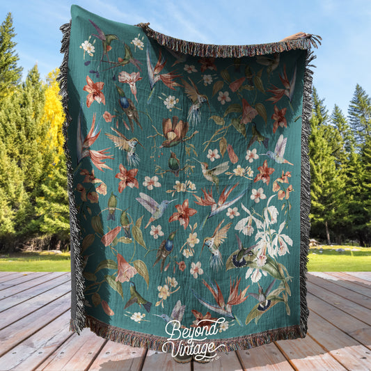 a green blanket with flowers and birds on it