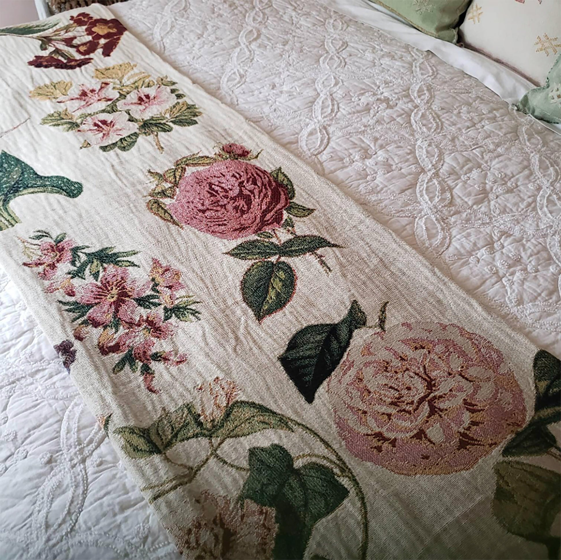 a bed with a white bedspread with pink flowers on it