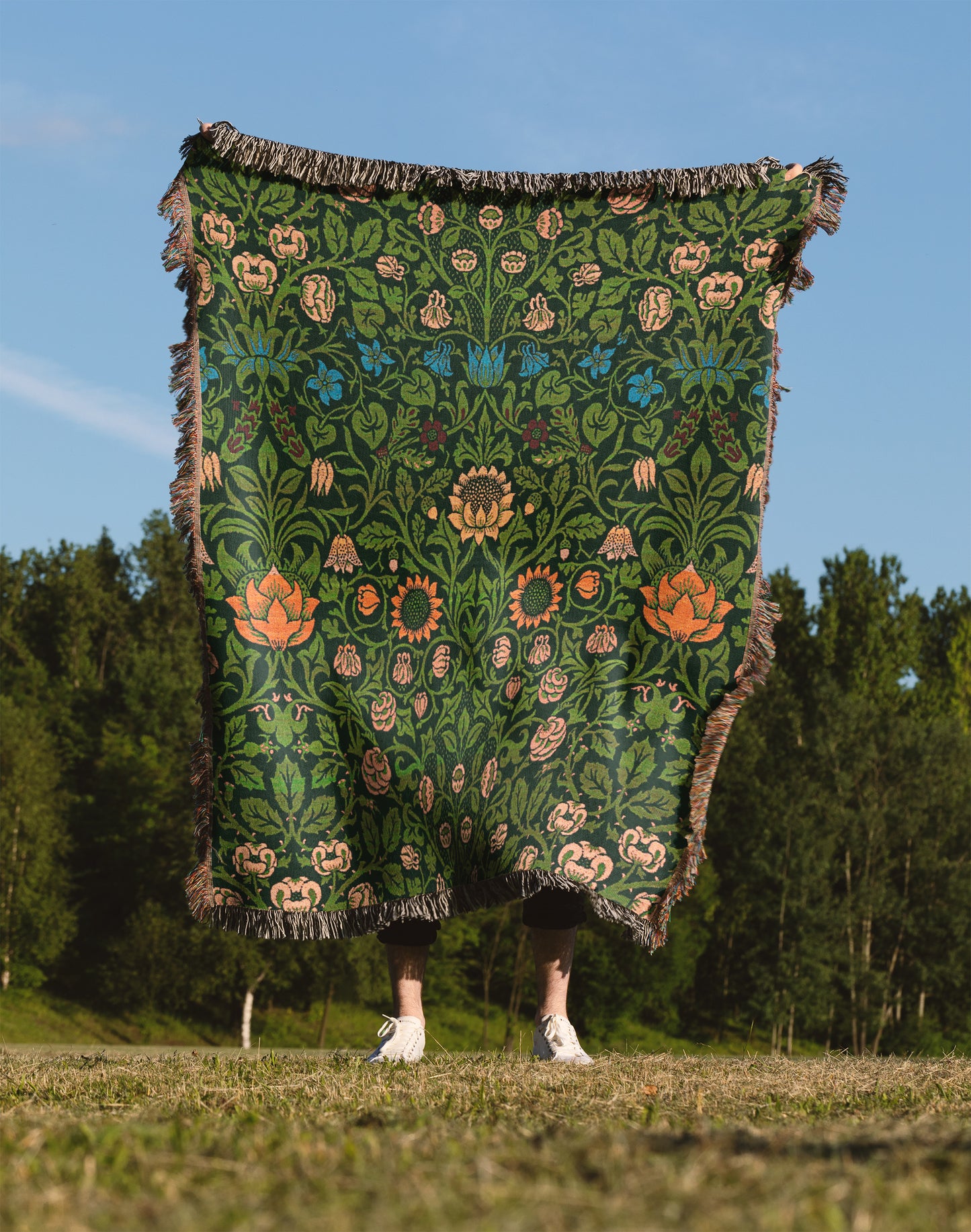 a person standing in a field holding a blanket