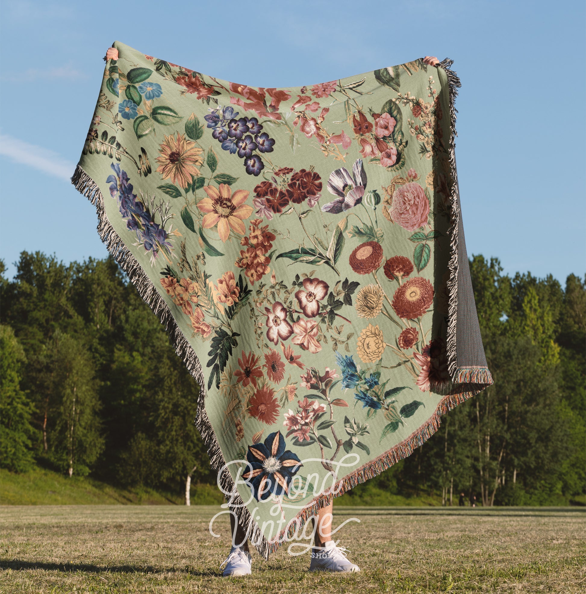 a woman standing in a field holding a blanket