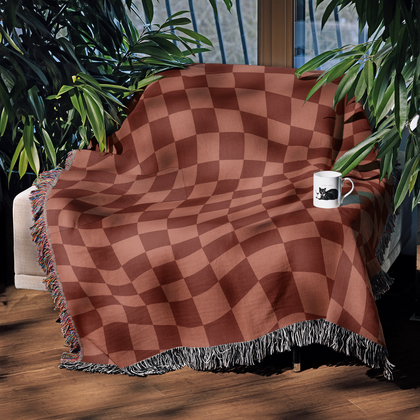 a coffee cup is sitting on a table under a blanket