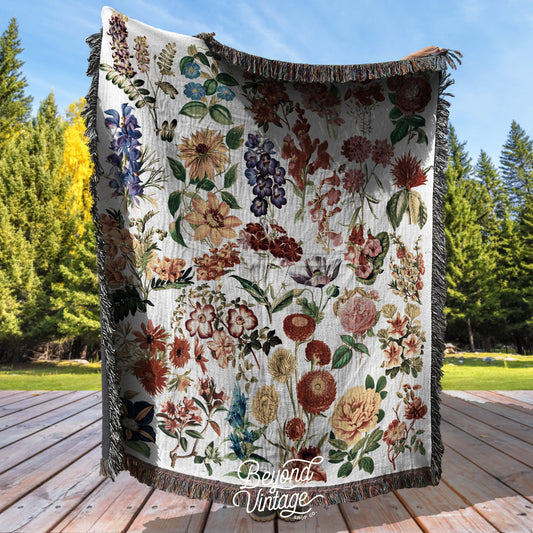 a quilt hanging on a wooden deck with trees in the background