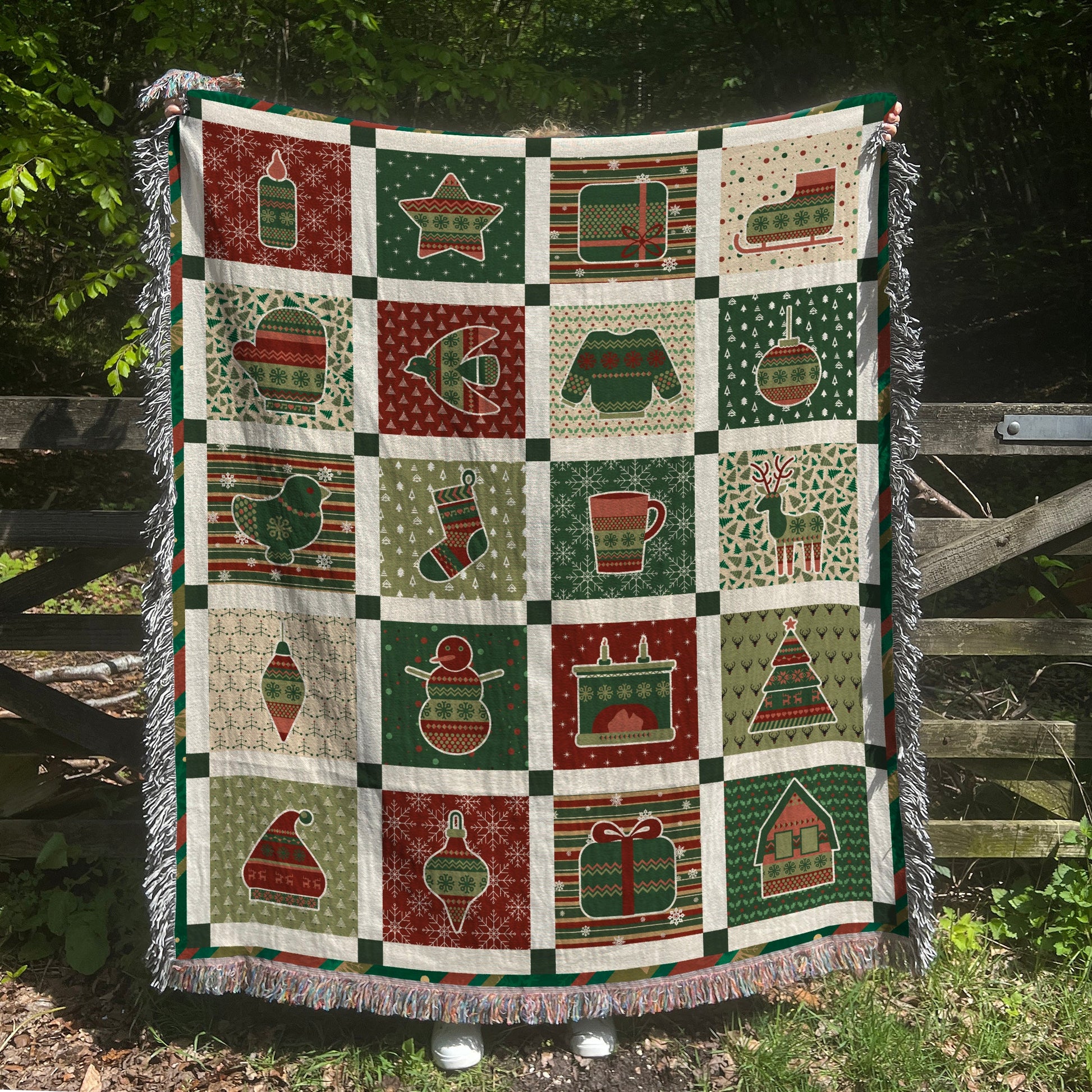 a green and red quilt hanging on a fence