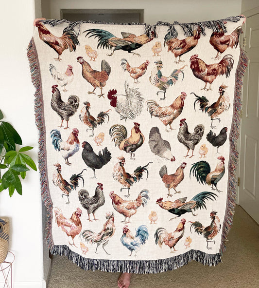 a woman standing in front of a quilt with roosters on it