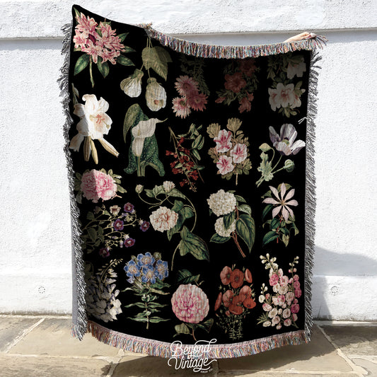 a black blanket with a bunch of flowers on it