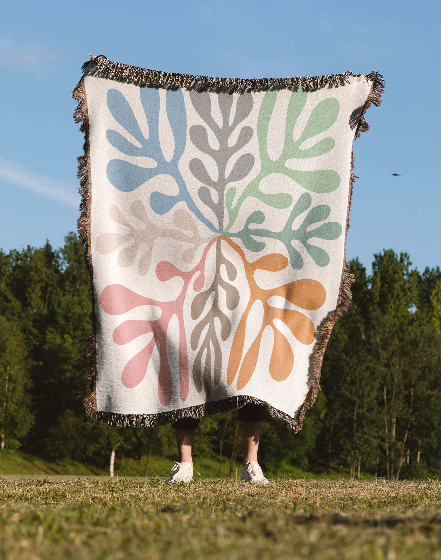 a person standing in a field holding a blanket