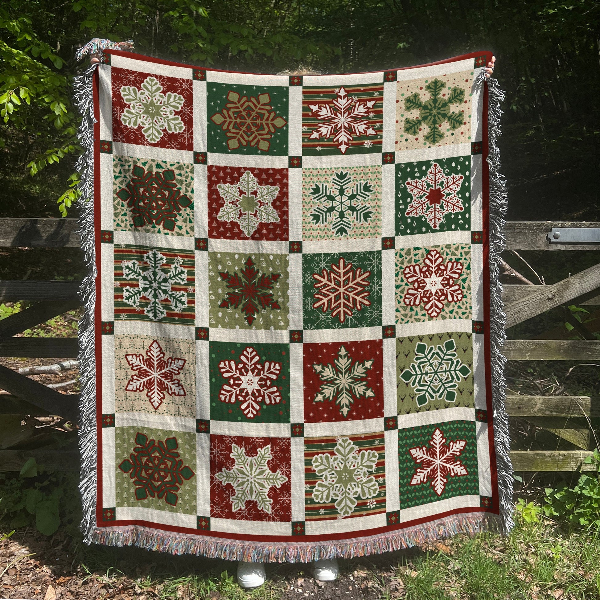 a quilt hanging on a fence with snowflakes on it