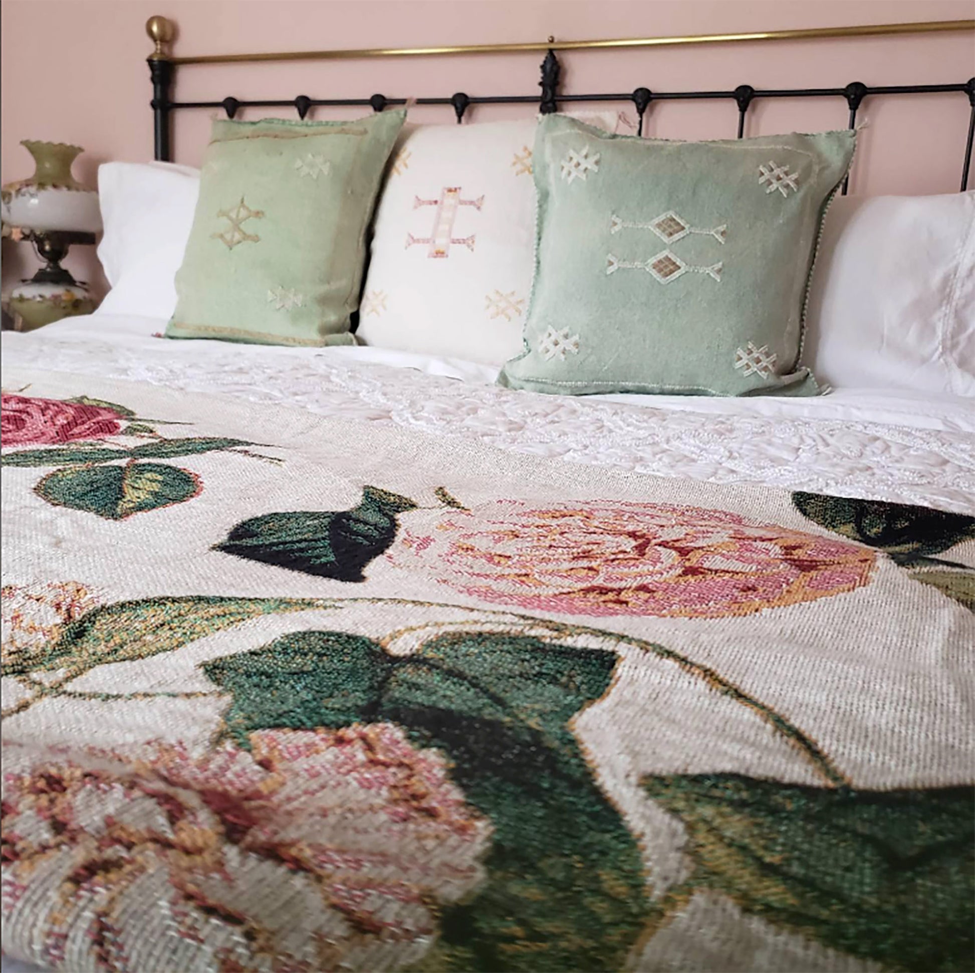 a bed with a floral comforter and pillows