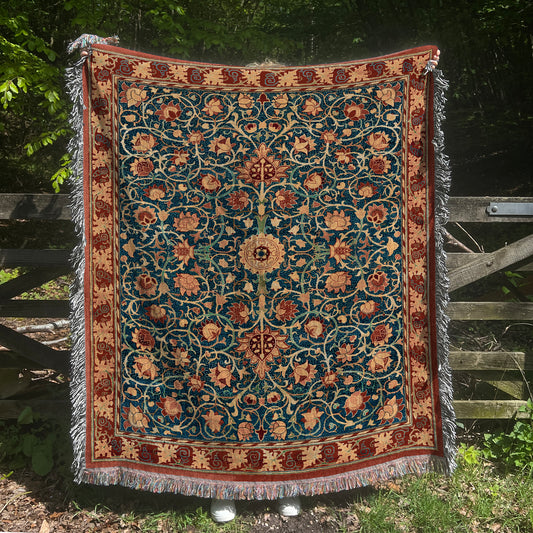 a blue and red rug hanging on a wooden fence