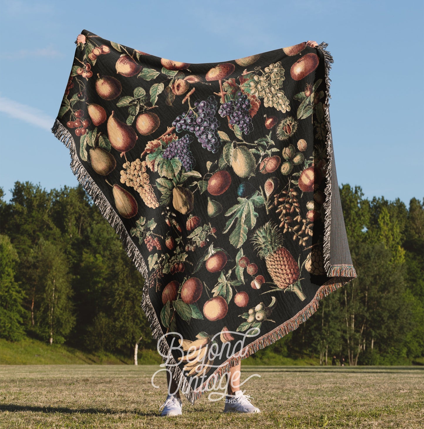 a woman is holding a blanket with fruit on it