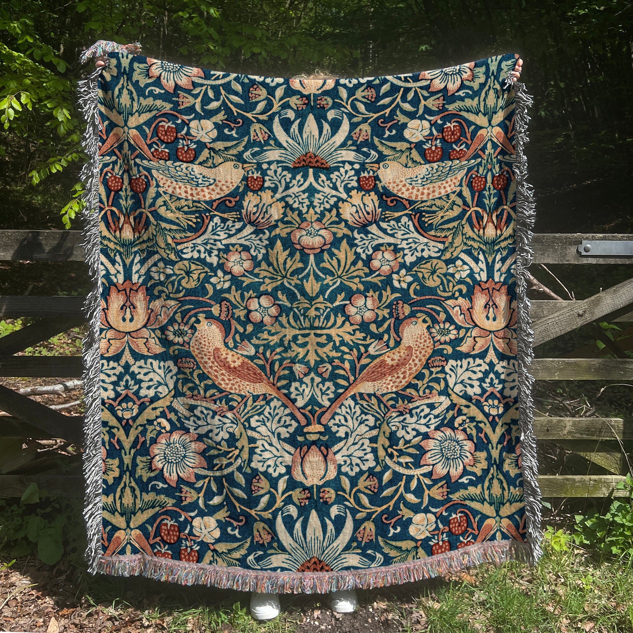 a tapestry hanging on a fence in a garden