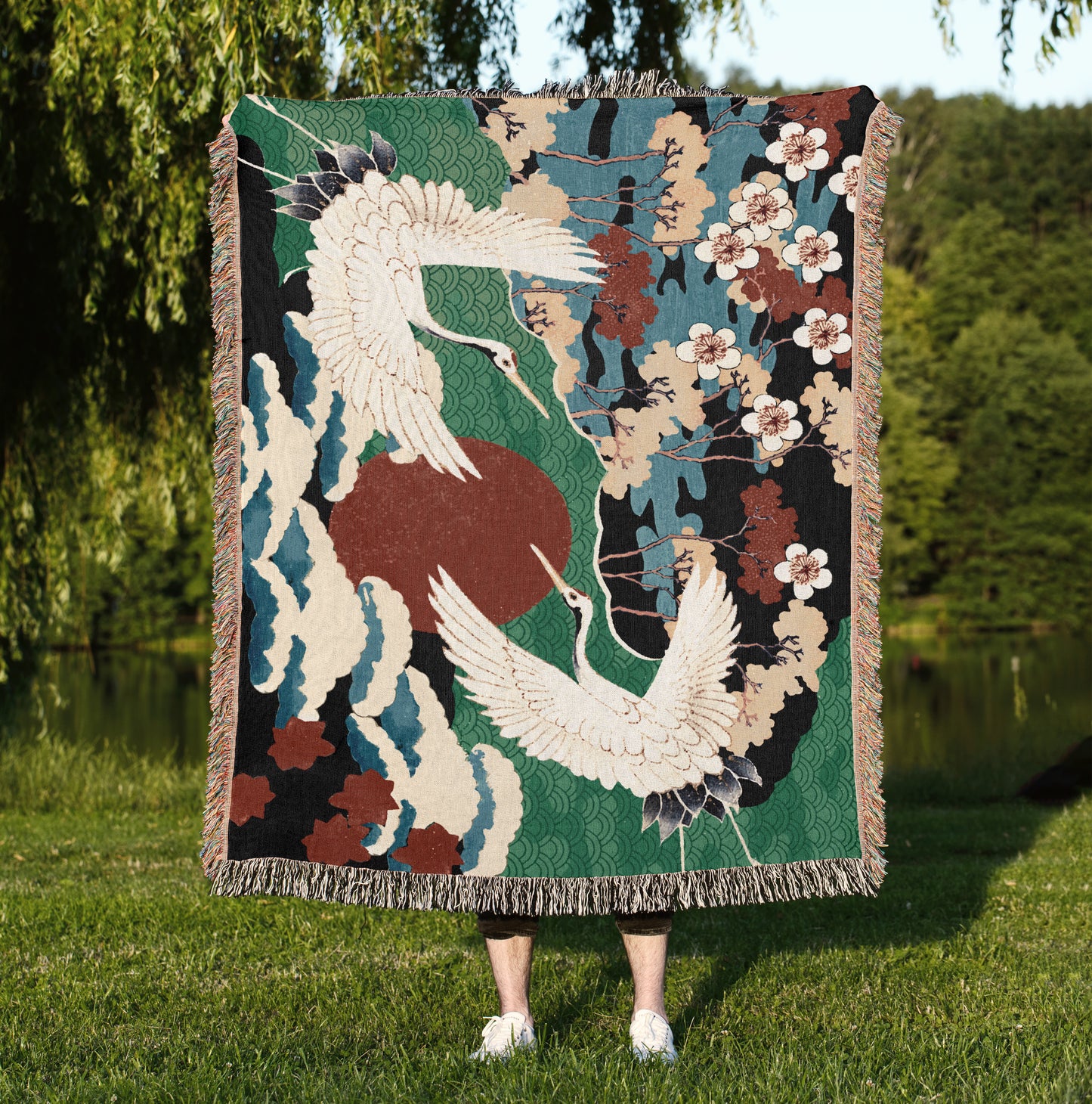 a woman standing in the grass holding a tapestry