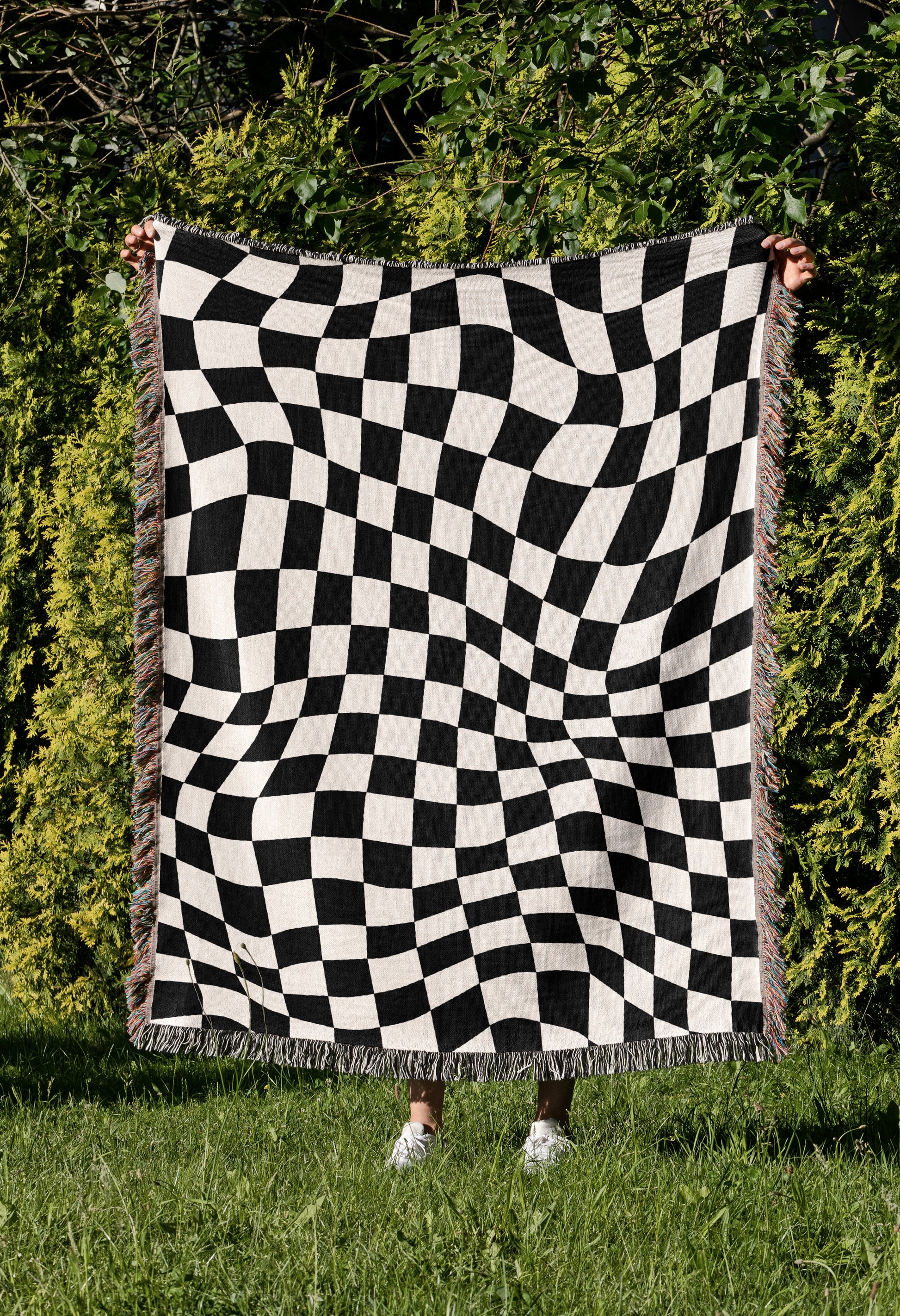 a person holding a black and white checkered blanket