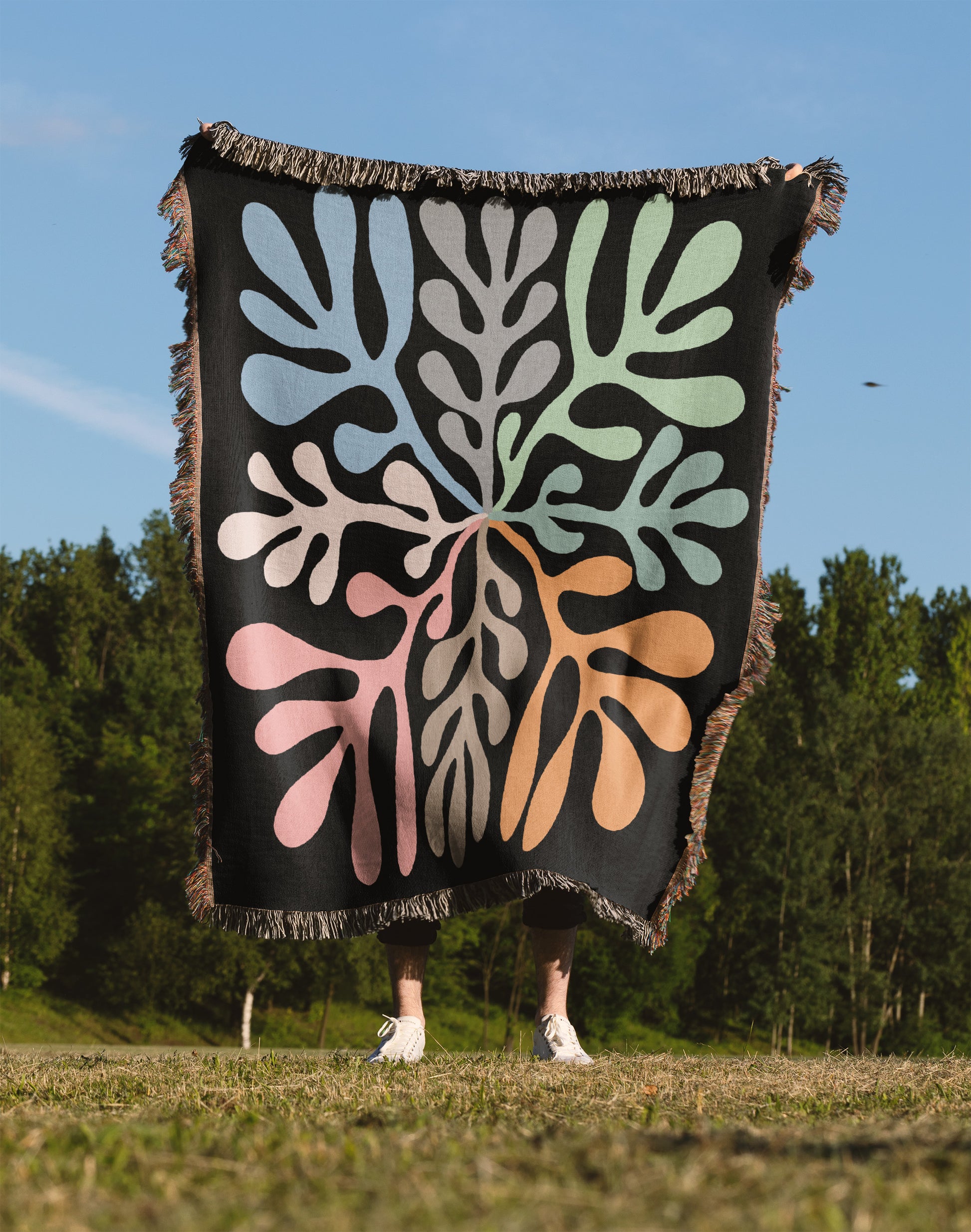 a person standing in a field holding a blanket