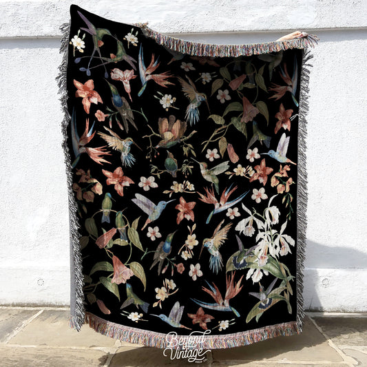 a black blanket with flowers and birds on it