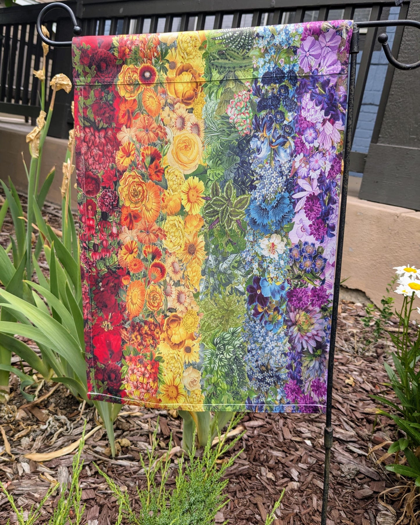 a quilt hanging on a clothes line in a garden