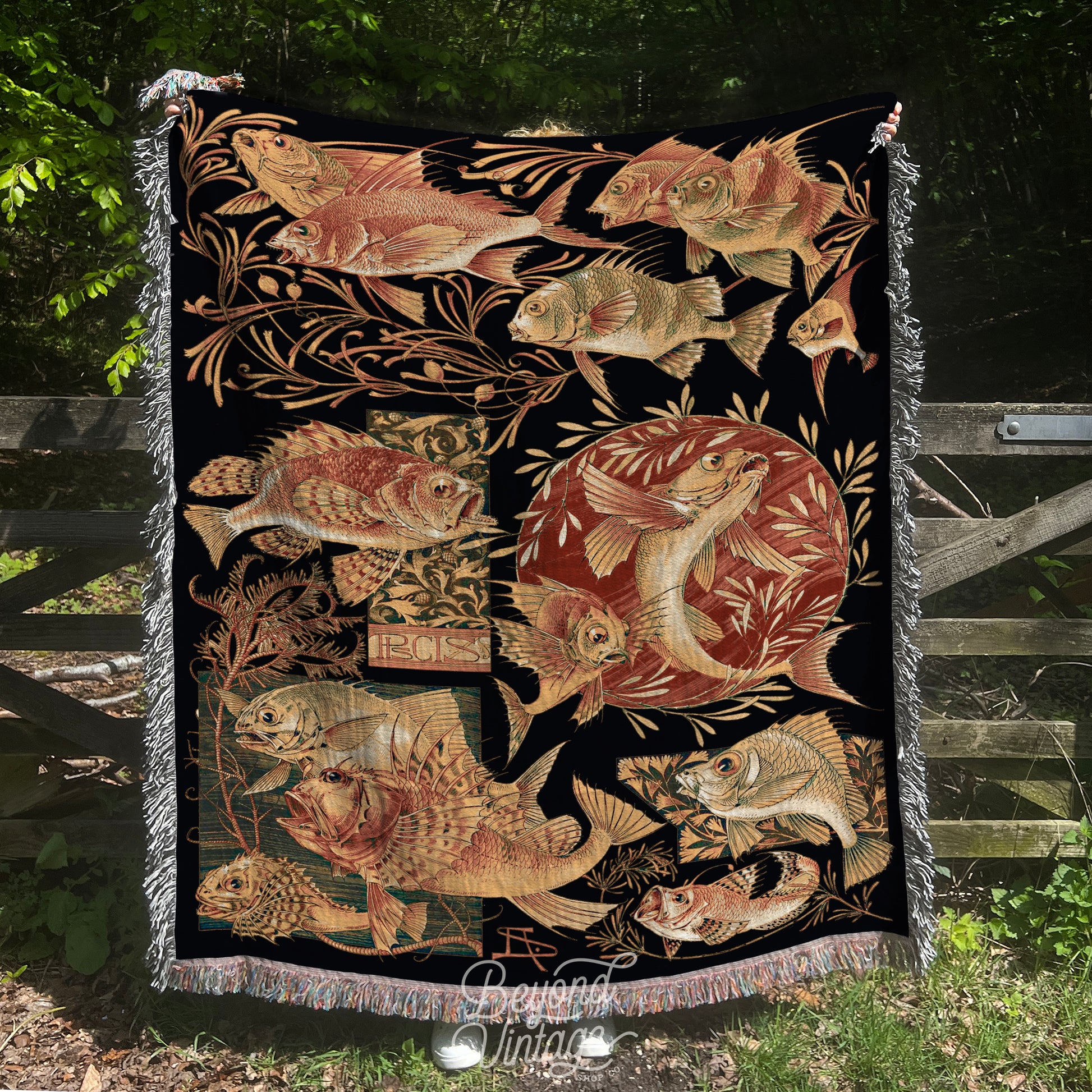 a tapestry hanging on a fence in the grass