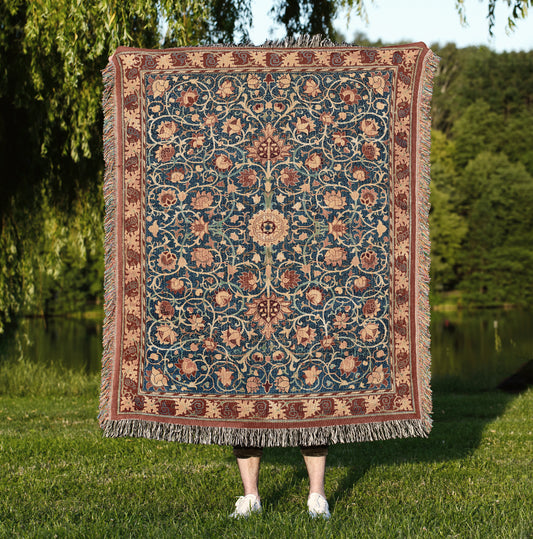 a woman standing in the grass holding a large rug