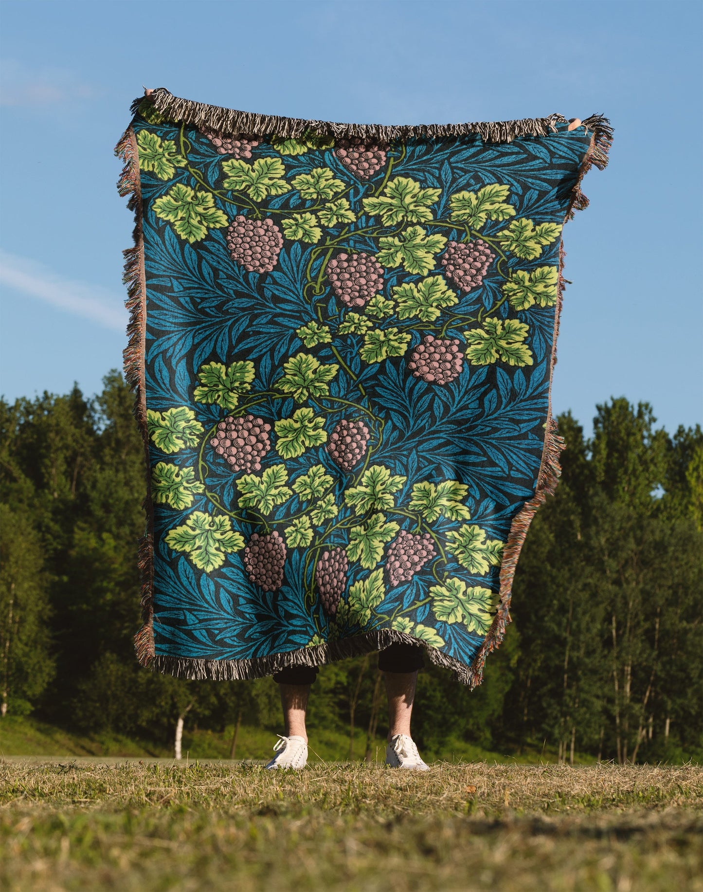 a person standing in a field holding a blanket