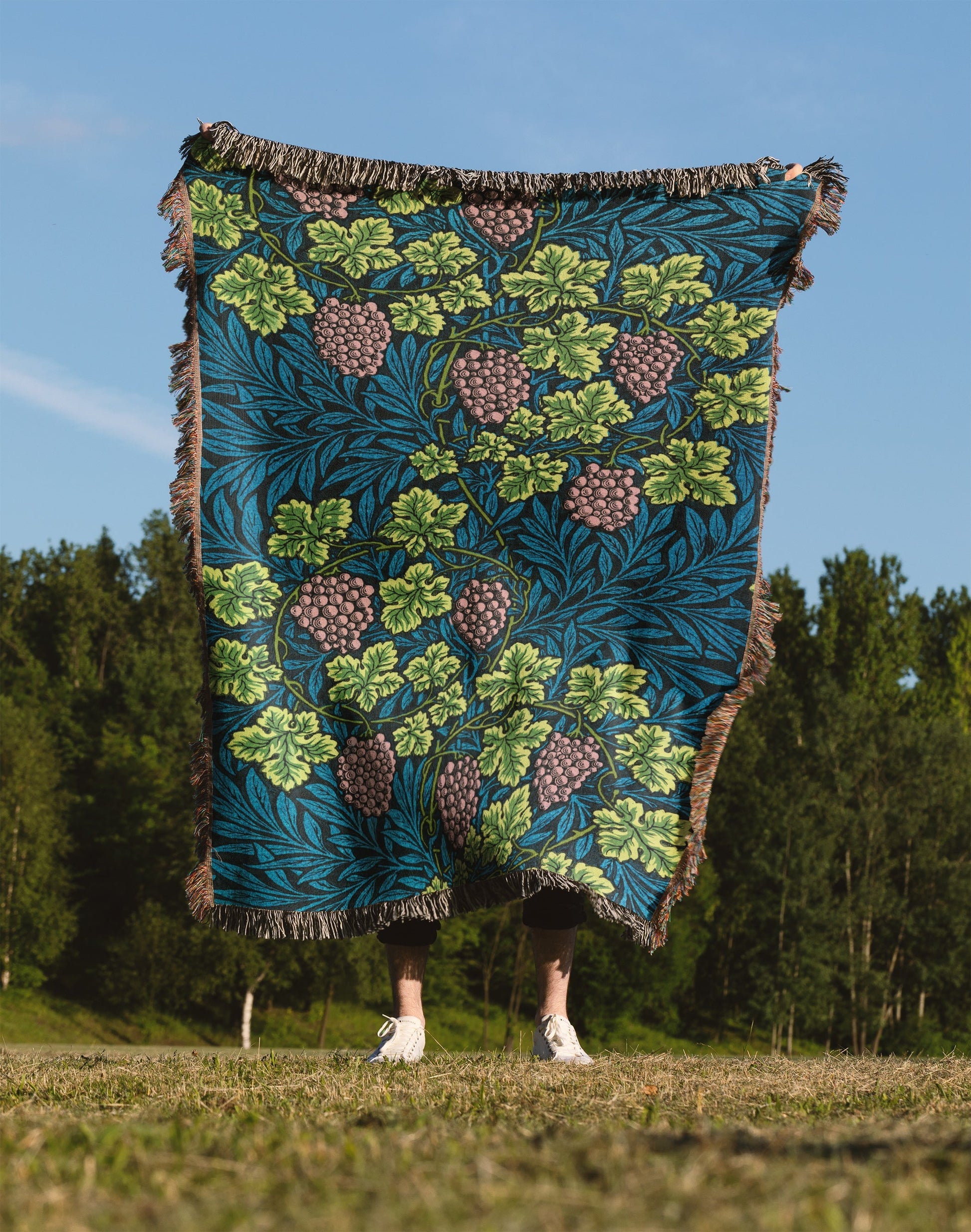 a person standing in a field holding a blanket