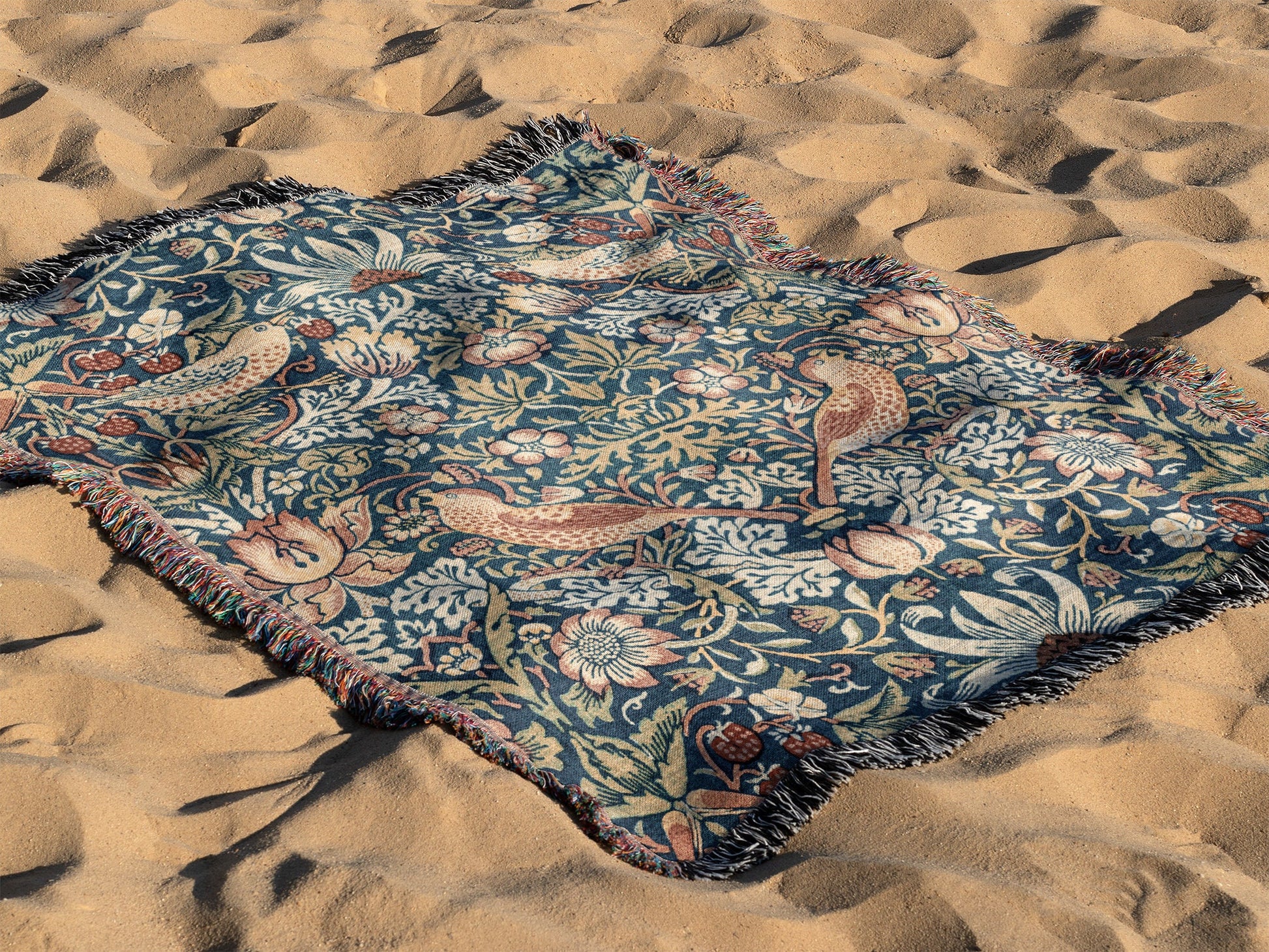 a blanket laying on top of a sandy beach