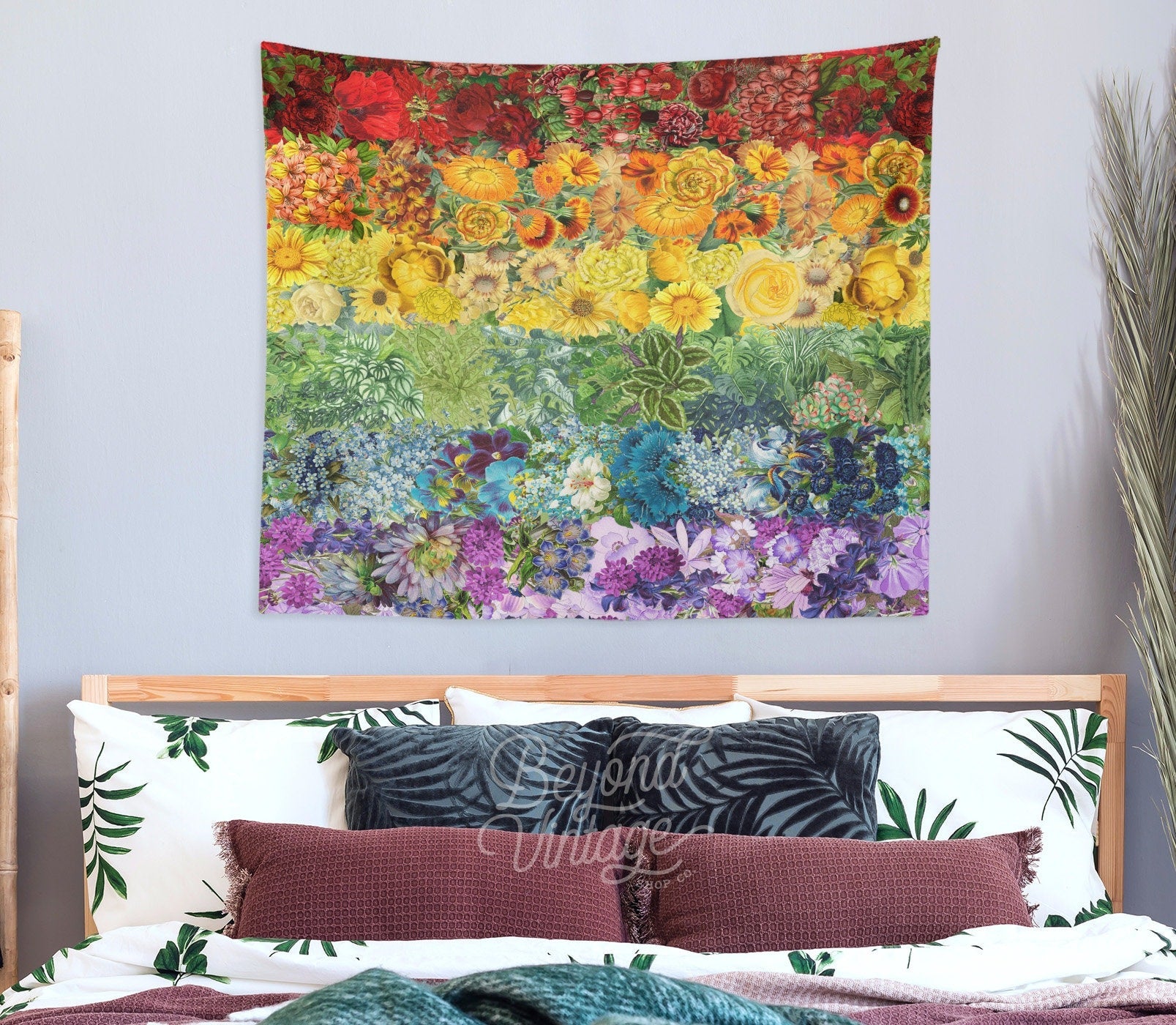 a bed with a colorful tapestry hanging above it