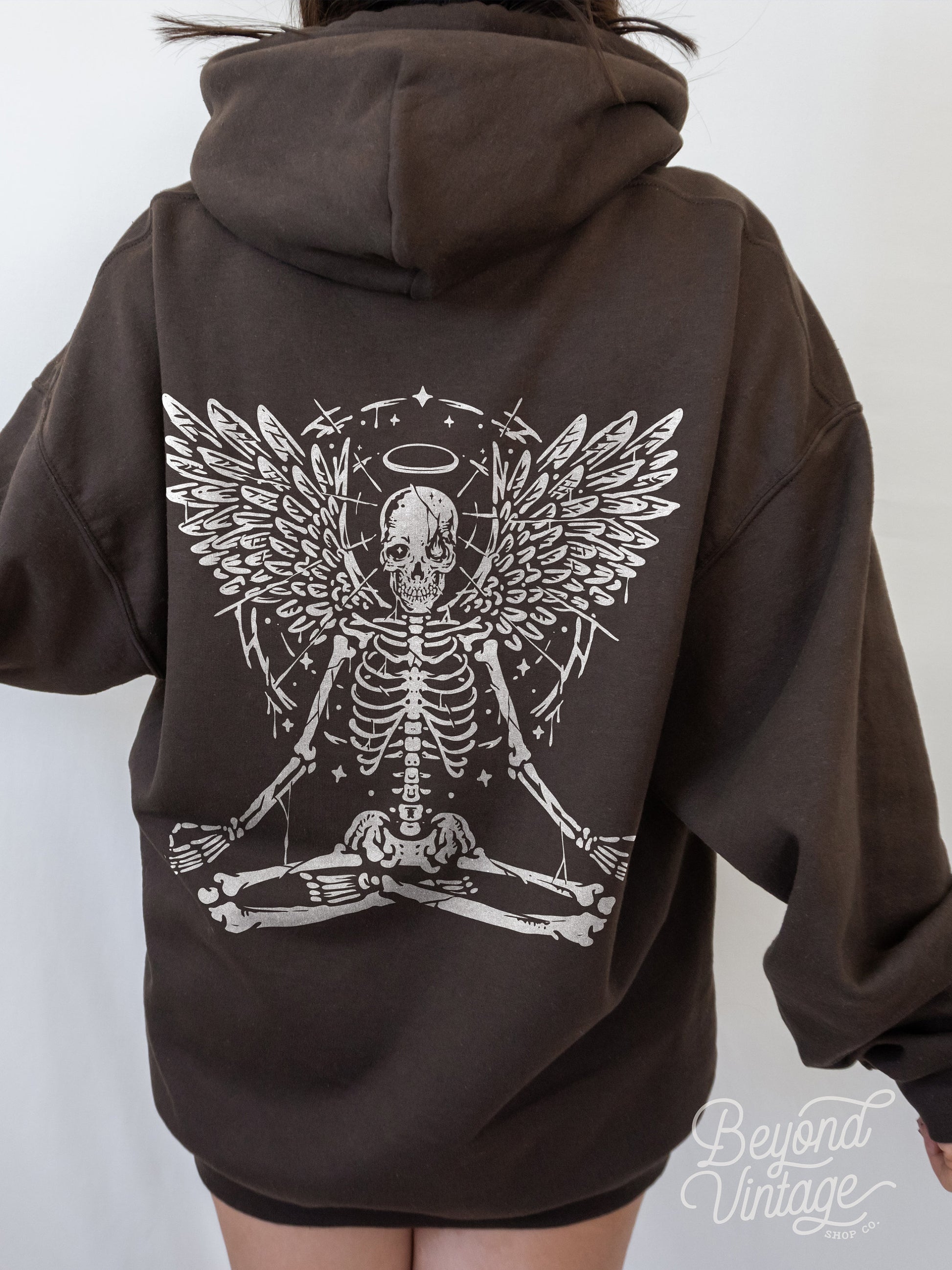 a woman wearing a brown hoodie with a skeleton on it