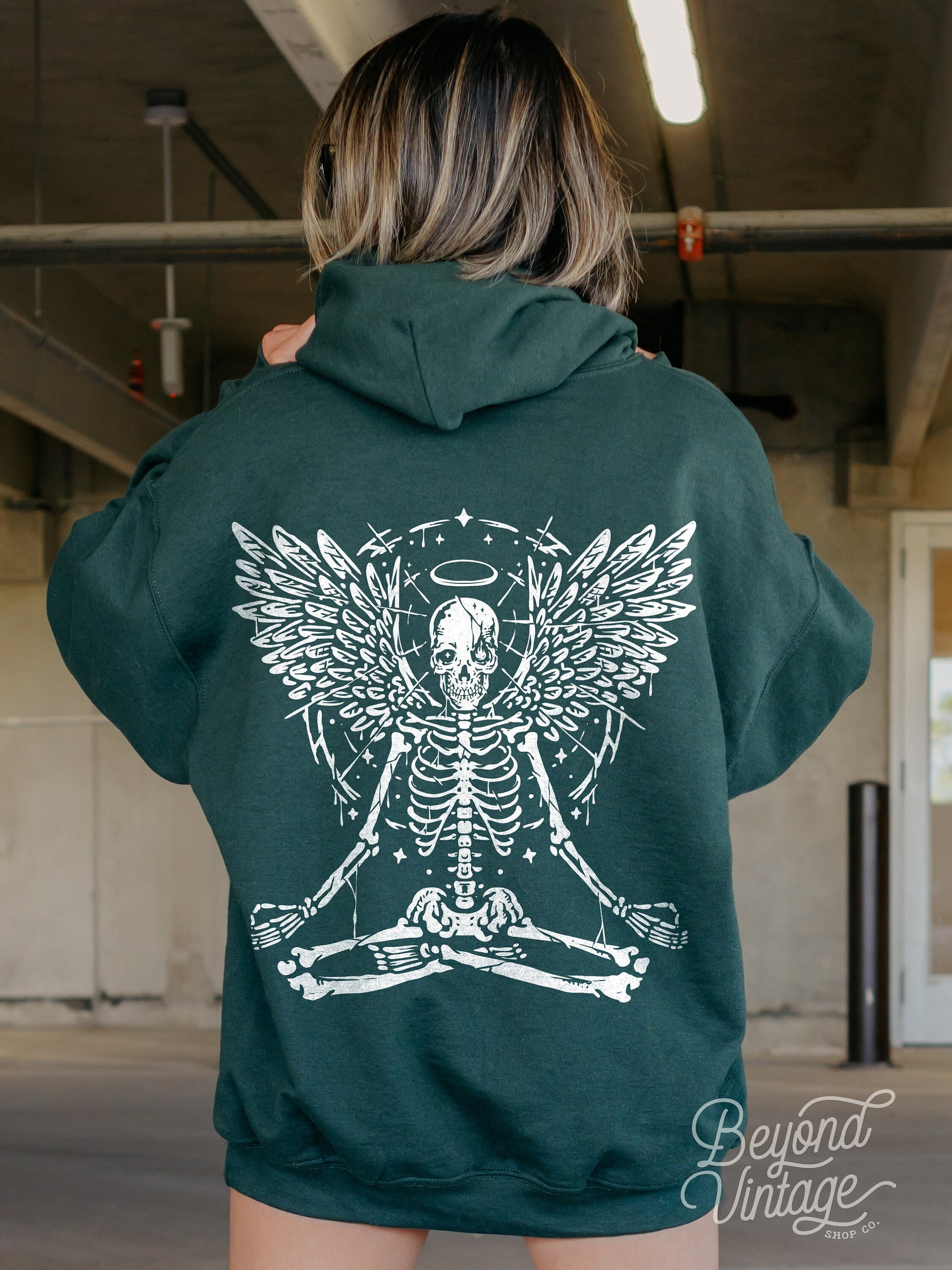 a woman wearing a green hoodie with a skeleton on it