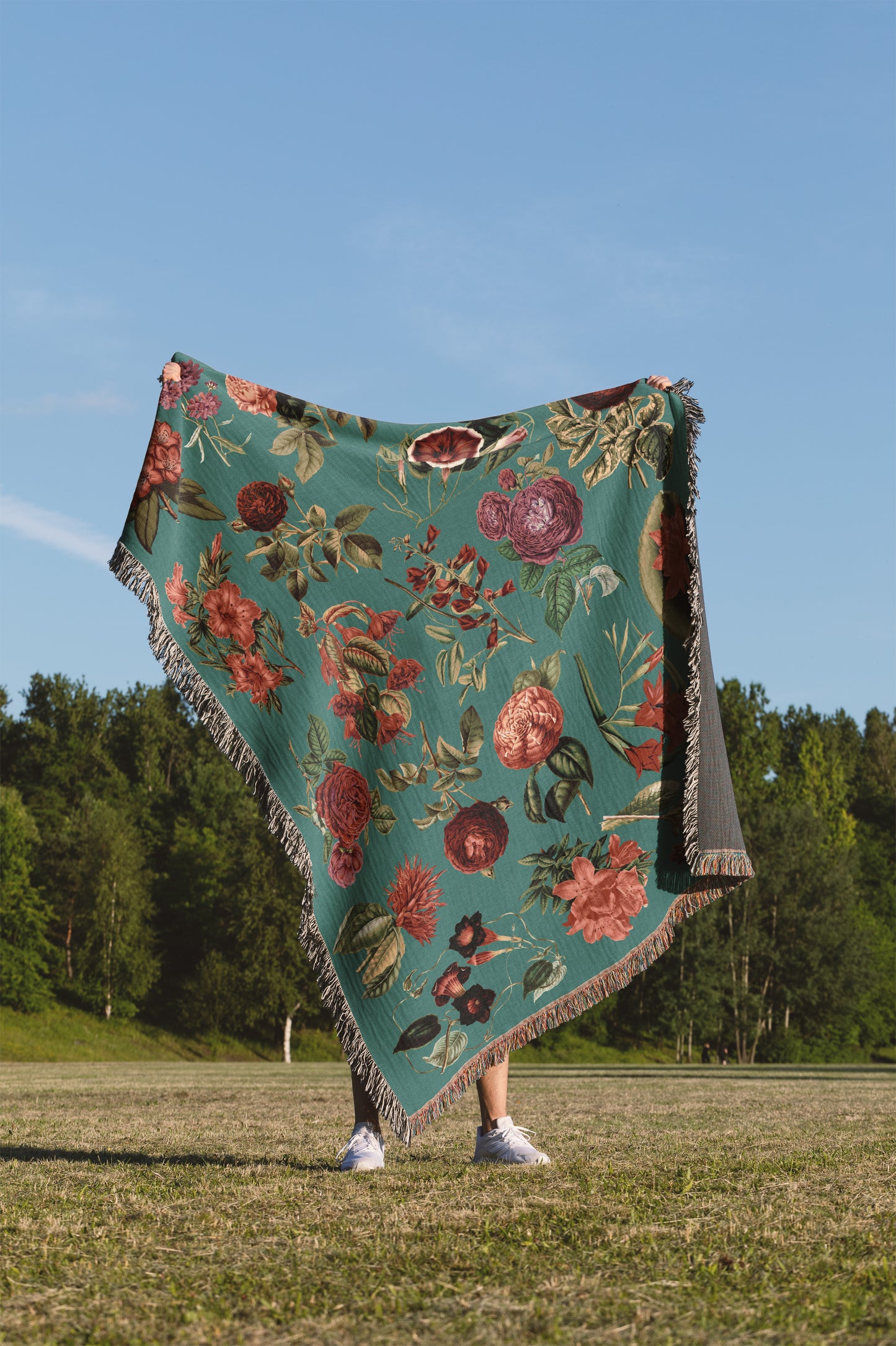 a woman standing in a field holding a blanket