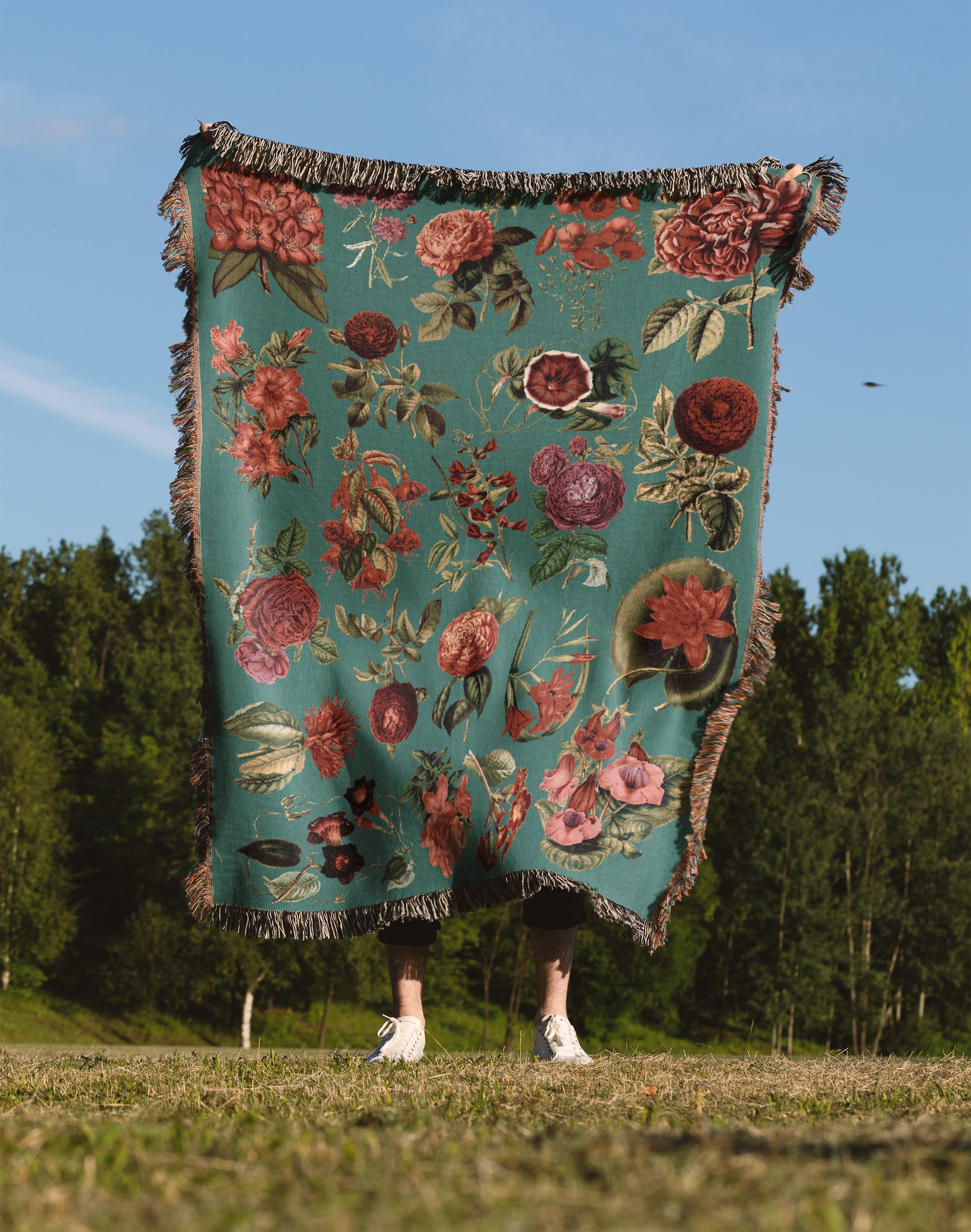 a person standing in a field holding a blanket