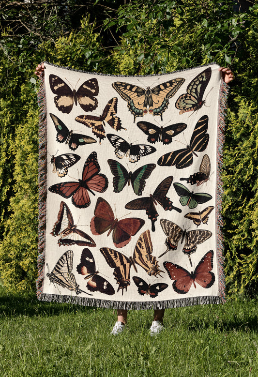 a woman holding a blanket with a bunch of butterflies on it