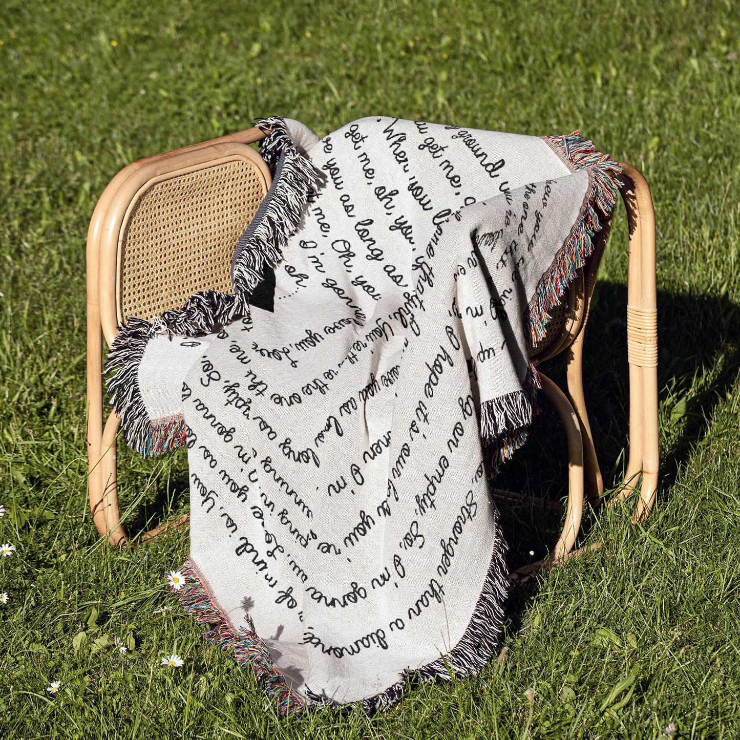 a chair sitting in the grass with a blanket on top of it