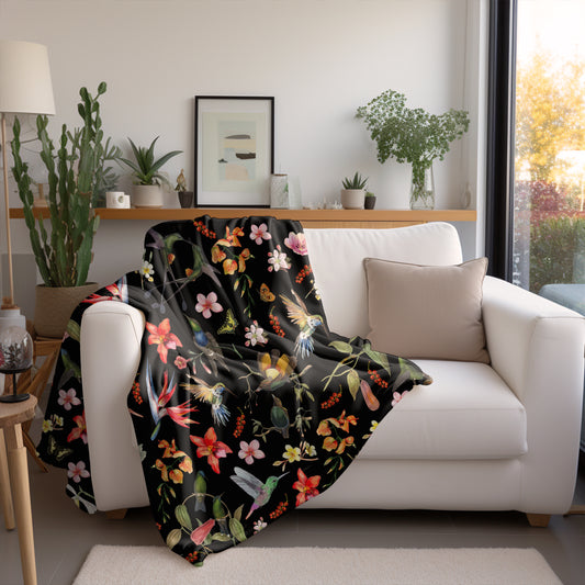 a living room with a white couch covered in a black floral blanket