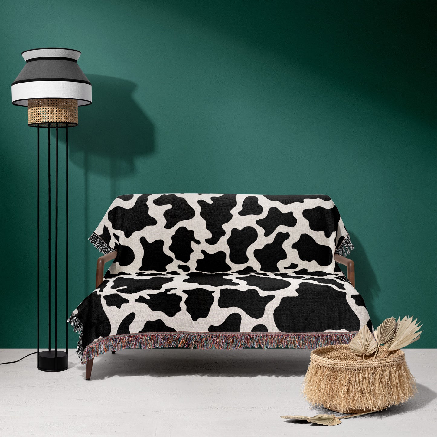 a living room with a cow print couch and floor lamp