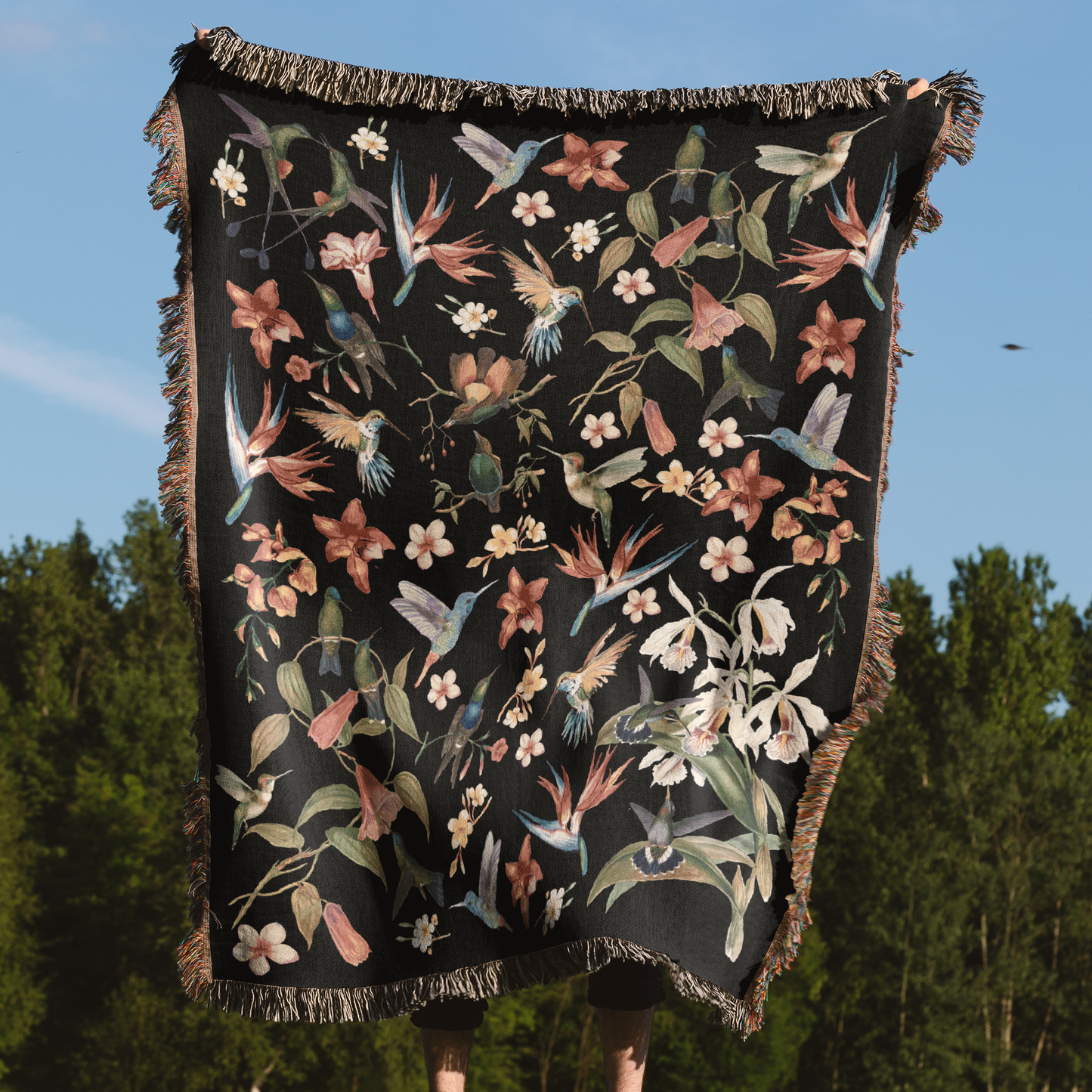 a black blanket with flowers and birds on it